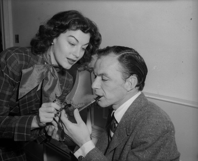 A atriz Ava Gardner ajuda seu marido, Frank Sinatra, a acender seu cachimbo - 11/12/1951