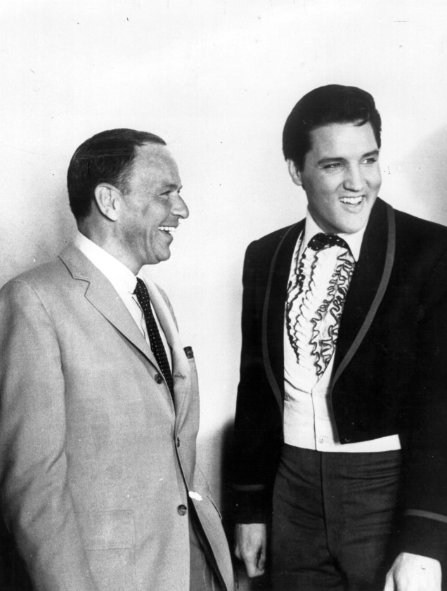 As vozes masculinas mais populares dos anos 50 Frank Sinatra e Elvis Presley, compartilham uma piada em Hollywood, Califórnia. Sinatra estava no set do filme 'Frankie And Johnny' e Presley tinha acabado de doar US $ 50 mil para o Fundo de Alívio de Cinema para ajudar atores e atrizes carentes - 18/06/1955