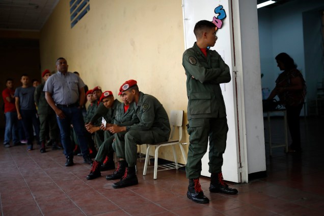Soldados e civis venezuelanos esperam para votar em um centro de votação durante a eleição presidencial em Caracas - 20/05/2018