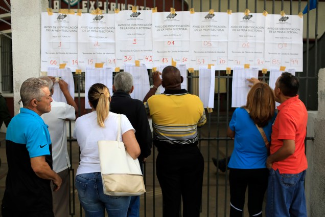 Cidadãos venezuelanos checam listas eleitorais em uma seção eleitoral durante a eleição presidencial em Caracas - 20/05/2018
