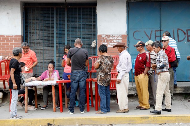Cidadãos venezuelanos fazem check-in em um "ponto vermelho",  área criada pelo partido do presidente Nicolás Maduro, para verificar se eles votaram durante a eleição presidencial em Barquisimeto - 20/05/2018
