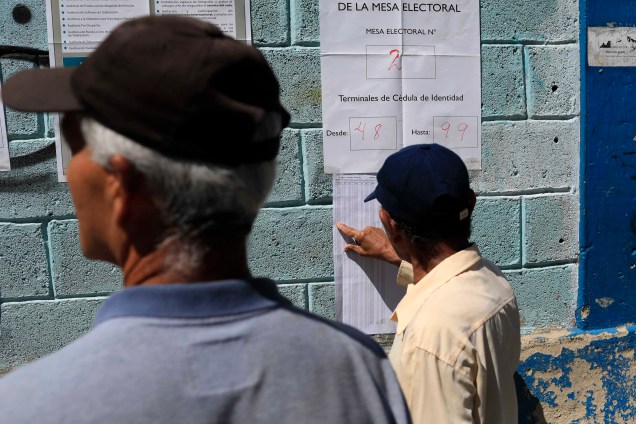 Cidadãos venezuelanos checam listas eleitorais em um centro de votação durante a eleição presidencial em Caracas - 20/05/2018