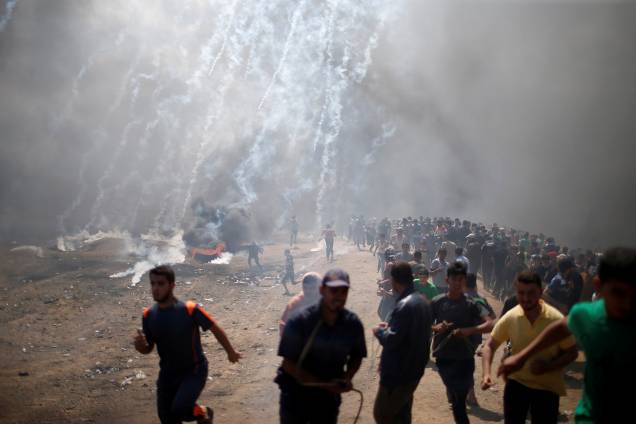 Manifestantes Palestinos fogem de bombas de gás lacrimogênio na Faixa de Gaza - 14/05/2018