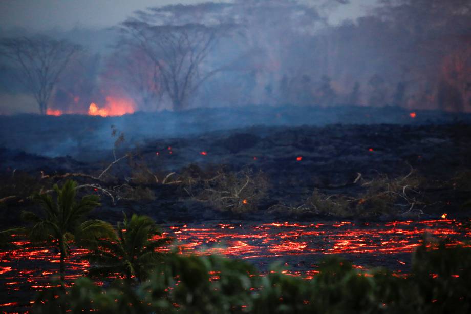 Lava flui perto de árvores nos arredores de Pahoa durante as contínuas erupções do vulcão Kilauea, no Havaí - 19/05/2018