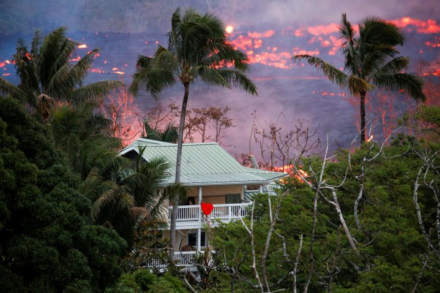 Lava flui perto de uma casa nos arredores de Pahoa durante as contínuas erupções do vulcão Kilauea, no Havaí - 19/05/2018