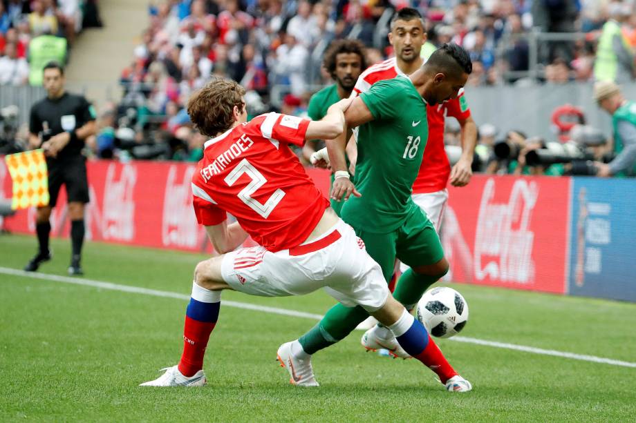 Salem Al-Dawsari, da Arábia Saudita, em ação com o russo Mario Fernandes, durante o primeiro jogo da Copa do Mundo Rússia 2018, no estádio Luzhniki, em Moscou - 14/06/2018