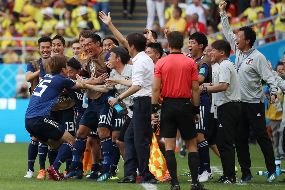 O japonês Yuya Osako comemora o gol marcado junto ao técnico Akira Nishino e os companheiros do banco de reservas