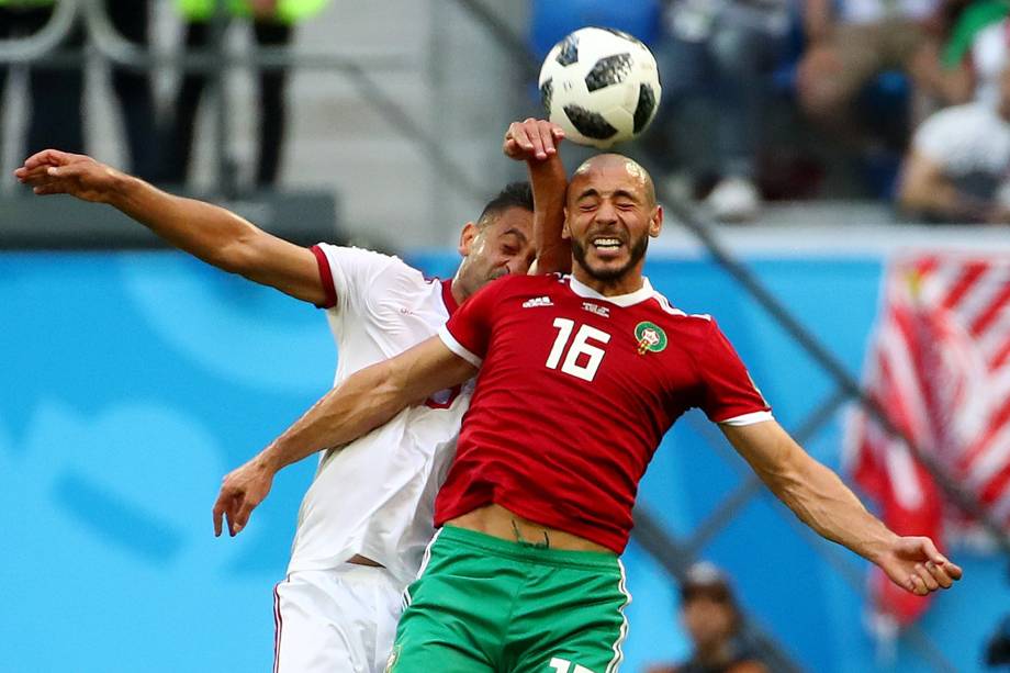 Omid Ebrahimi do Irã disputa pelo alto com Nordin Amrabat do Marrocos na partida de estreia das seleções do Grupo B no estádio São Petesburgo - 15/06/2018
