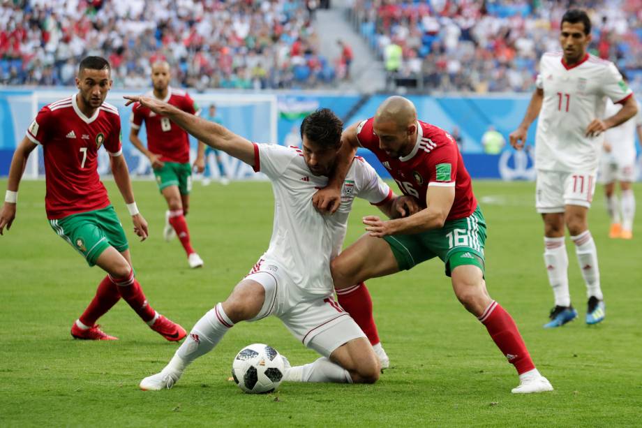 Karim Ansarifard do Irã disputa jogada com Nordin Amrabat do Marrocos na partida de estreia das seleções do Grupo B no estádio São Petesburgo - 15/06/2018