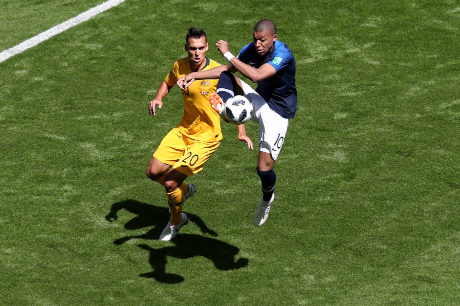 O atacante Kylian Mbappé da França domina a bola marcado de perto pelo zagueiro Trent Sainsbury da Austália