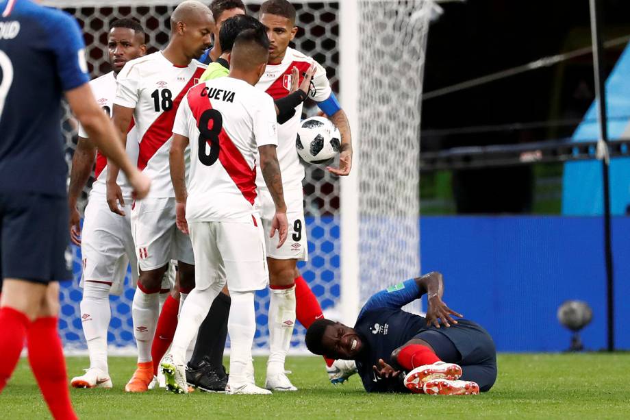 Jogadores peruanos observam o francês Samuel Umtiti, que reage após uma falta sofrida - 21/06/2018