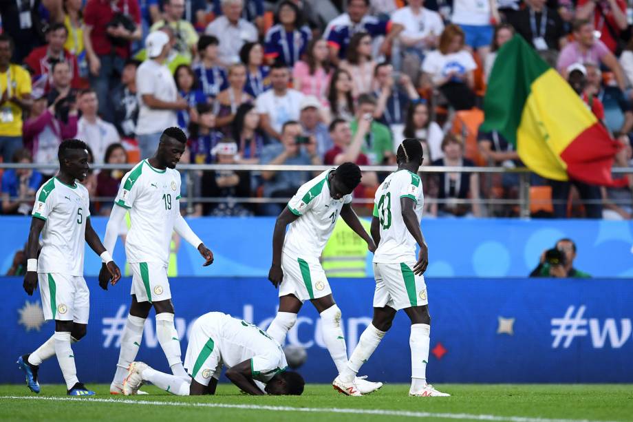 Moussa Wague, do Senegal, encosta a cabeça no gramado durante a comemoração do segundo gol contra o Japão - 24/06/2018