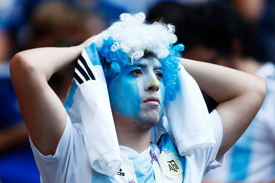 Um torcedor com o rosto pintado como a bandeira da Argentina, reage durante a derrota para a França, na Arena Kazan - 30/06/2018