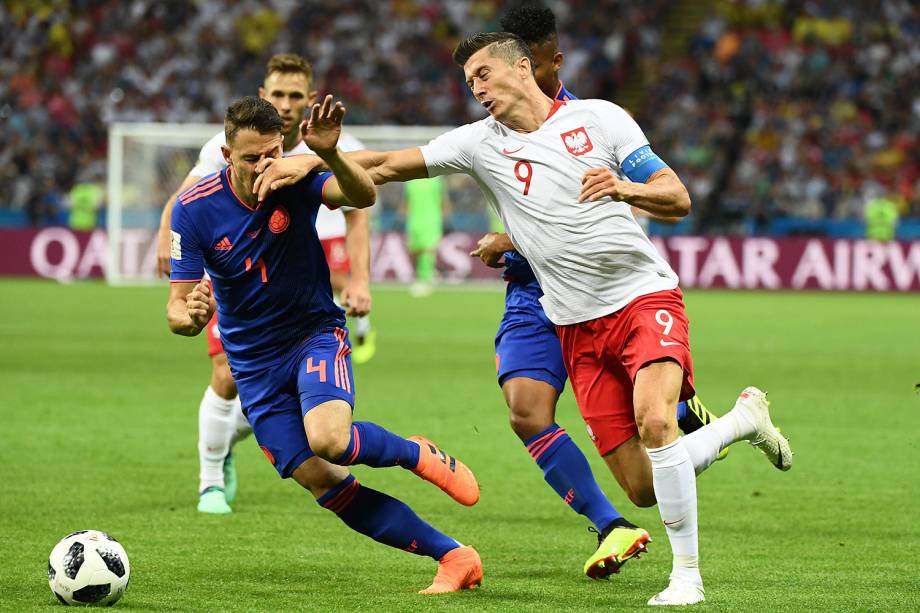 O zagueiro colombiano, Santiago Arias, é atingido pelo braço de Robert Lewandowski, da Polônia, durante uma disputa de bola - 24/06/2018