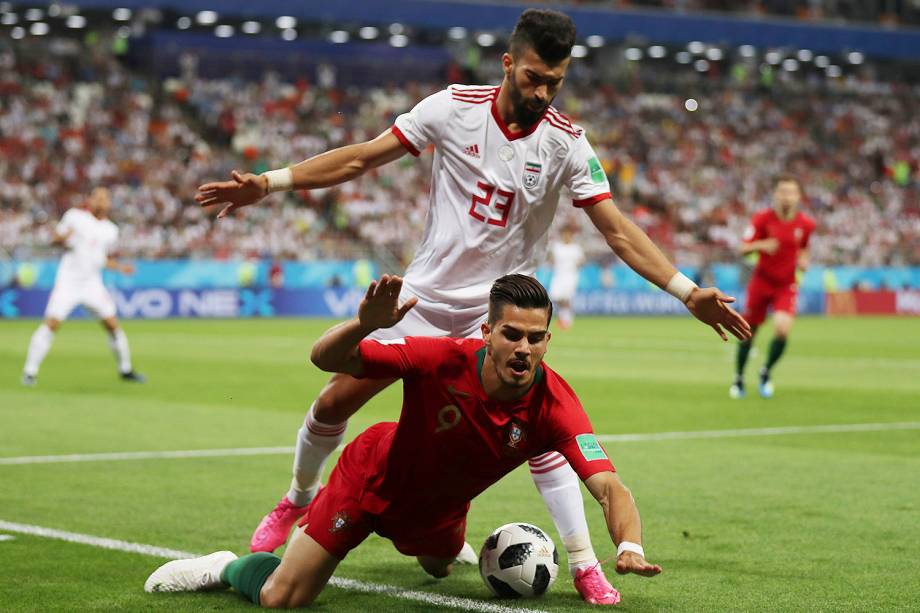 Andre Silva, de Portugal, é derrubado por Ramin Rezaeian, do Irã, durante uma tentativa de roubada de bola - 25/06/2018