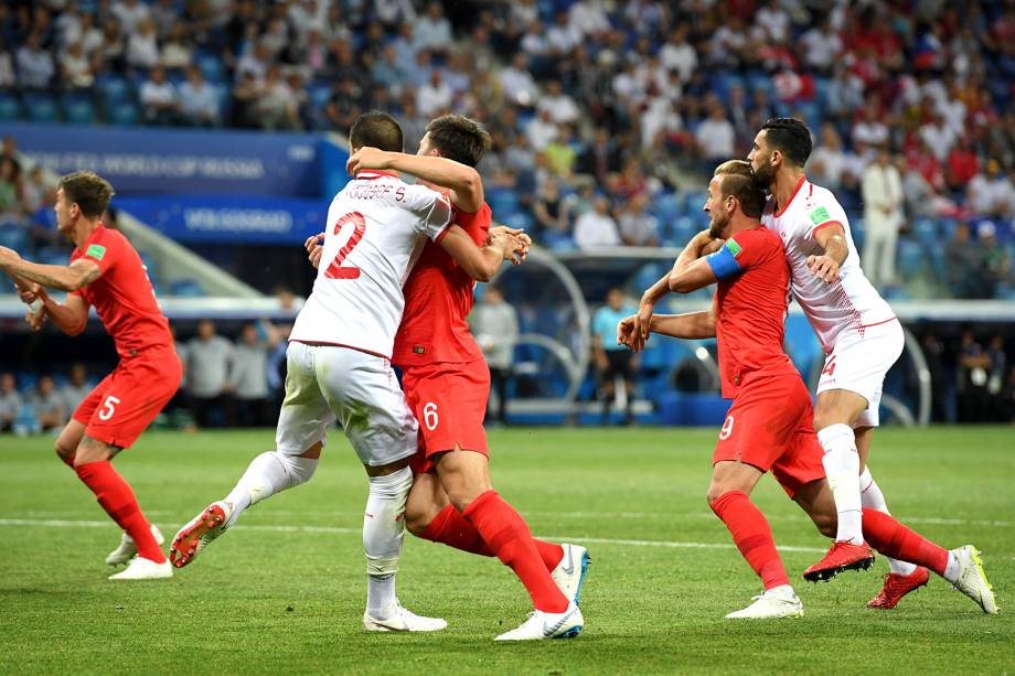 Syam Ben Youssef, da Tunísia, e Harry Maguire, da Inglaterra disputam posição durante a cobrança de um escanteio