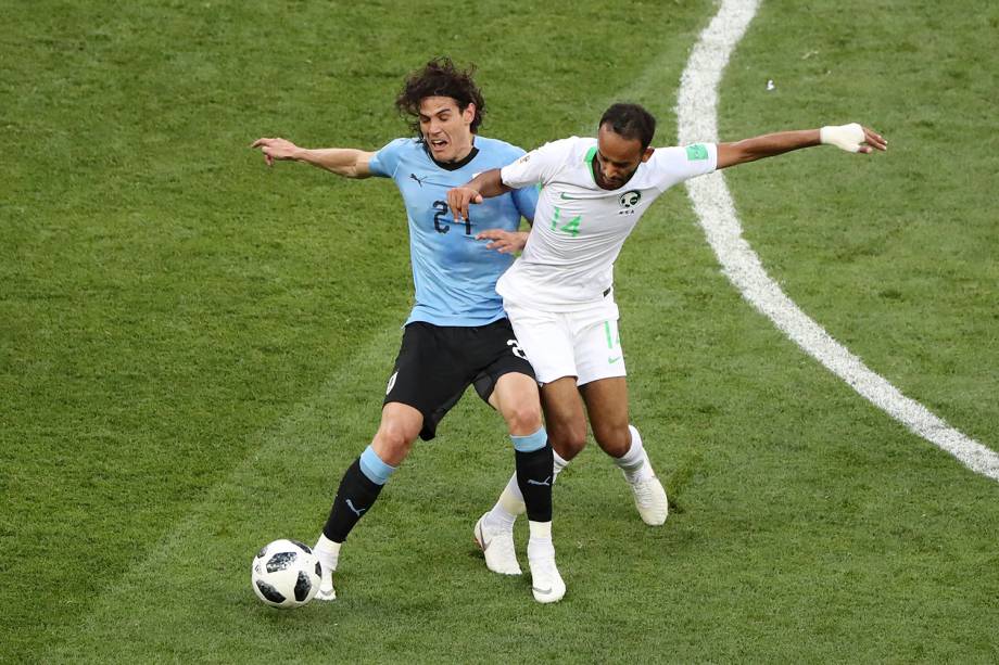 Edinson Cavani, do Uruguai, recebe falta ao proteger a bola de Abdullah Otayf, da Arábia Saudita