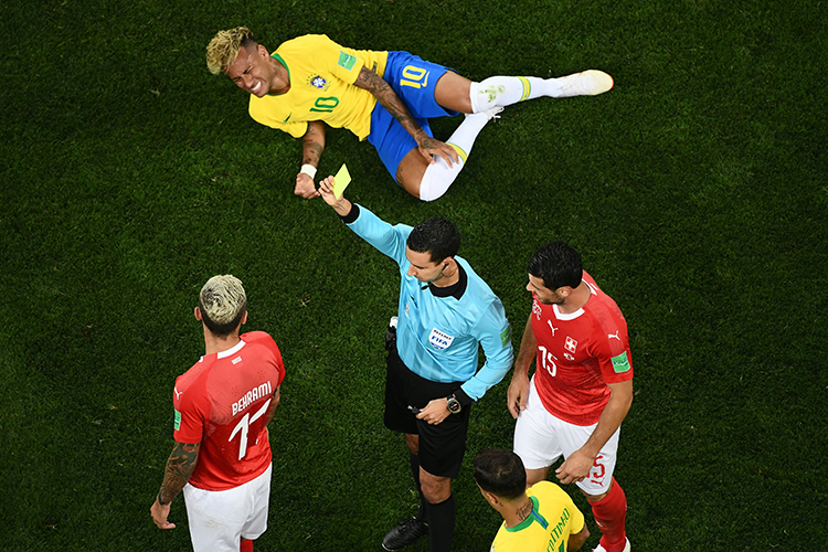 O árbitro Cesar Ramos adverte o jogador Valon Behrami com cartão amarelo, após cometer falta em Neymar, durante jogo entre Brasil e Suíça - 17/06/2018