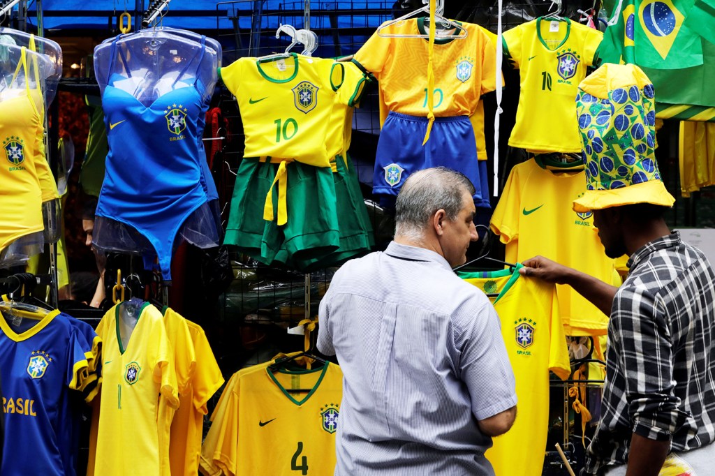Consumidores observam camisas da Seleção Brasileira à venda, em uma loja de São Paulo (SP) - 13/06/2018