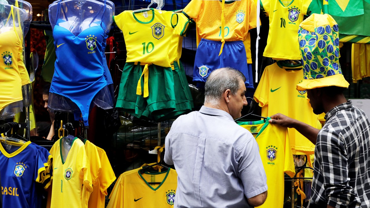 Consumidores observam camisas da Seleção Brasileira à venda, em uma loja de São Paulo (SP) - 13/06/2018