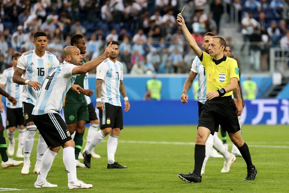 O árbitro Cuneyt Cakir mostra cartão amarelo para Javier Mascherano, durante partida entre Nigéria e Argentina - 26/06/2018