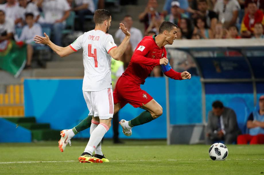 Cristiano Ronaldo de Portugal cai ao competir pela bola com Nacho da Espanha - 15/06/2018