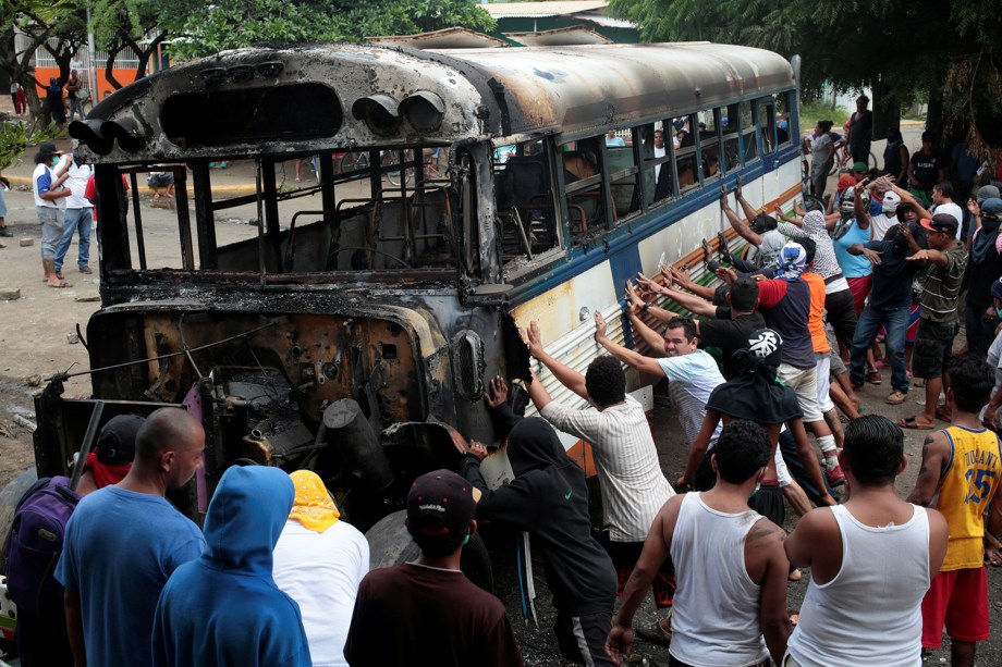 Manifestantes fazem barricada com ônibus incendiado em protesto ao Presidente Daniel Ortega em Tipitapa, Nicarágua - 14/06/2018