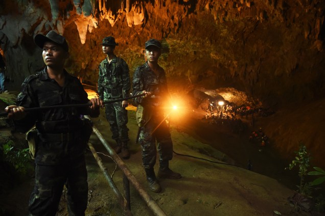 Soldados tailandeses conduzem o cabo elétrico para o interior da caverna de Tham Luang no parque nacional de Khun Nam Nang Non em Chiang Rai durante operação de salvamento de uma equipe de futebol infantil presa no local - 26/06/2018