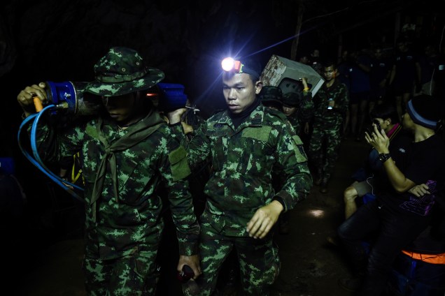 Soldados carregam equipamentos para o complexo de cavernas de Tham Luang, em busca de membros de um time de futebol sub-16 e seu treinador presos no local, na província de Chiang Rai, Tailândia - 26/06/2018