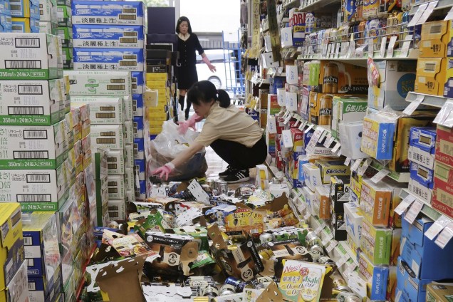 Funcionários removem garrafas e latas de bebidas espalhadas em uma loja após terremoto em Hirakata, Osaka, oeste do Japão - 18/06/2018