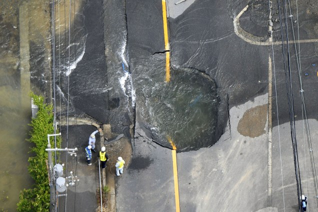 Água flui das rachaduras em uma estrada danificada por um terremoto em Takatsuki, Osaka, oeste do Japão - 18/06/2018