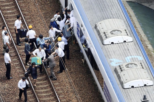 Passageiros saem de um trem cuja operação foi suspensa após um terremoto em Takatsuki, prefeitura de Osaka, oeste do Japão - 18/06/2018