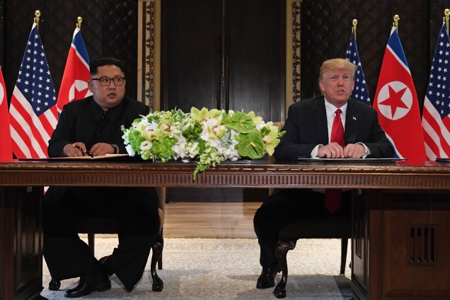 O presidente dos Estados Unidos, Donald Trump, e o ditador da Coreia do Norte, Kim Jong-un, assinam documentos após encontro no Hotel Capella, na ilha de Sentosa, em Singapura
