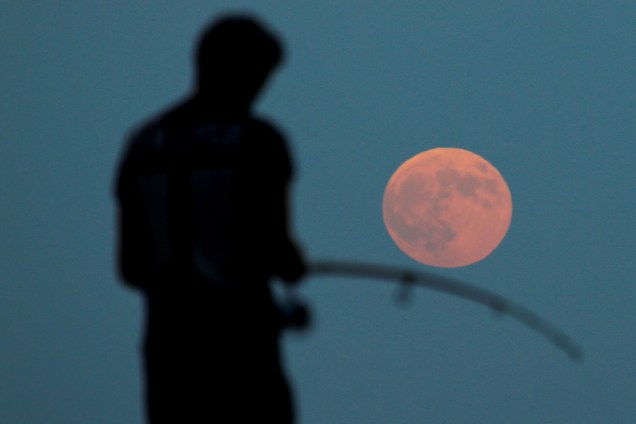 Homem realiza pescaria durante eclipse lunar com 'Lua de Sangue', em Antália, na Turquia - 27/07/2018