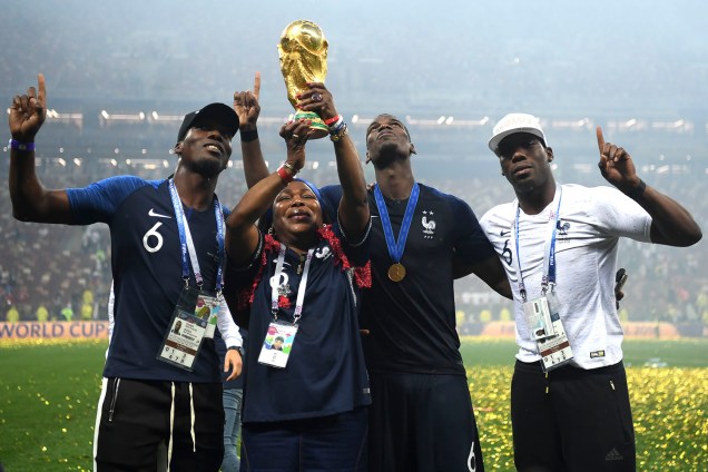 Yeo, a mãe do francês Paul Pogba, ergue a taça dos campeões do mundo enquanto comemora o título com seus filhos Mathias e Florentin - 15/07/2018