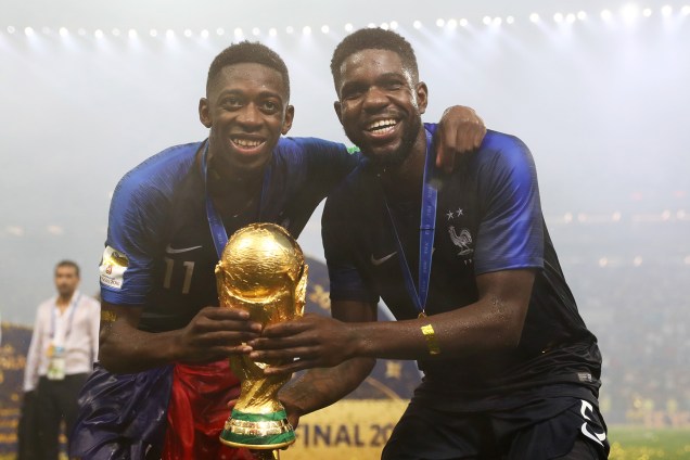 Samuel Umtiti e Ousmane Dembele comemoram com taça vitória na Copa do Mundo 2018 no Estádio Lujniki - 15/07/2018