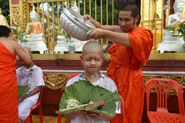 Um monge budista enxágua a cabeça de um dos integrantes do time "Javalis Selvagens" durante um ritual religioso no templo Phra That Doi Wao - 24/07/2018