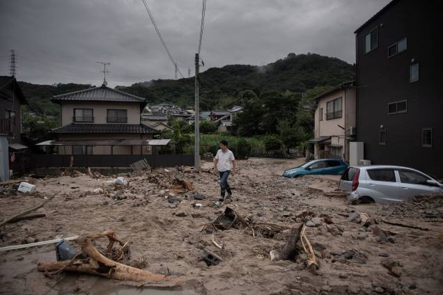 Um homem caminha por uma rua devastada durante as inundações em Saka, na província de Hiroshima, no Japão - 08/07/2018
