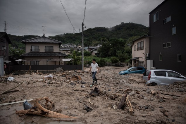 Um homem caminha por uma rua devastada durante as inundações em Saka, na província de Hiroshima, no Japão - 08/07/2018
