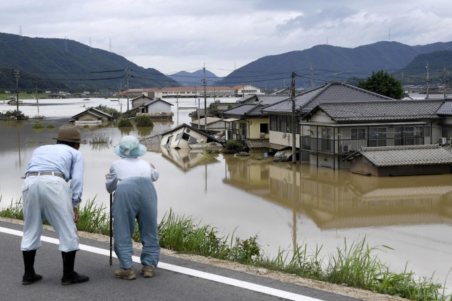 Casal de idosos olha para uma área inundada após a chuva pesada em Kurashiki, Prefeitura de Okayama, no Japão - 08/07/2018
