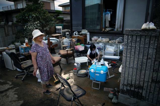 Residentes recolhem seus pertences em uma área inundada em Kurashiki, província de Okayama, Japão - 08/07/2018