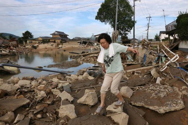 Moradora atravessa os escombros espalhados em uma área de enchente em Kurashiki, prefeitura de Okayama, no Japão - 09/07/2018