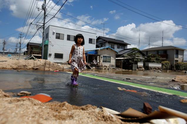 Criança caminha em uma área afetada pela enchente na cidade de Mabi em Kurashiki, Prefeitura de Okayama, Japão - 10/07/2018