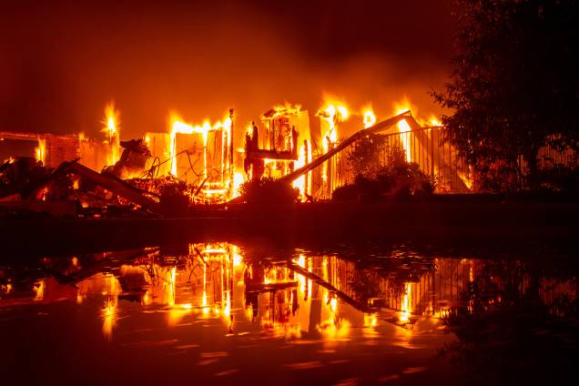 Casa em chamas reflete nas águas de uma piscina durante o incêndio Carr, que atinge a cidade de Redding, na Califórnia - 27/07/2018