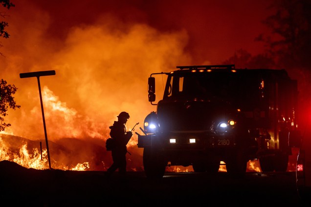 Bombeiro é visto ao lado do caminhão durante o combate ao incêndio florestal Carr, na cidade de Redding, Califórnia - 27/07/2018