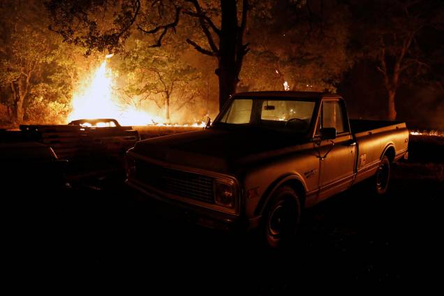 Chamas do incêndio florestal Carr queimam atrás de uma caminhonete na cidade de Redding, na Califórnia - 27/07/2018