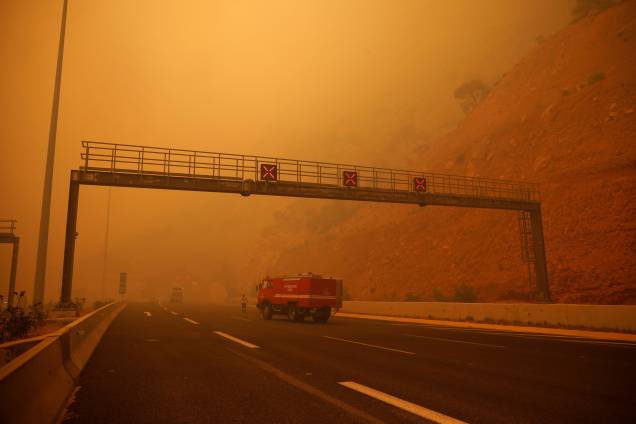 Uma densa camada de fumaça cobre uma estrada durante um incêndio florestal em Kineta, perto de Atenas, na Grécia - 23/07/2018