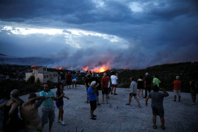 Moradores observam incêndio florestal na cidade de Rafina, perto de Atenas, na Grécia - 23/07/2018