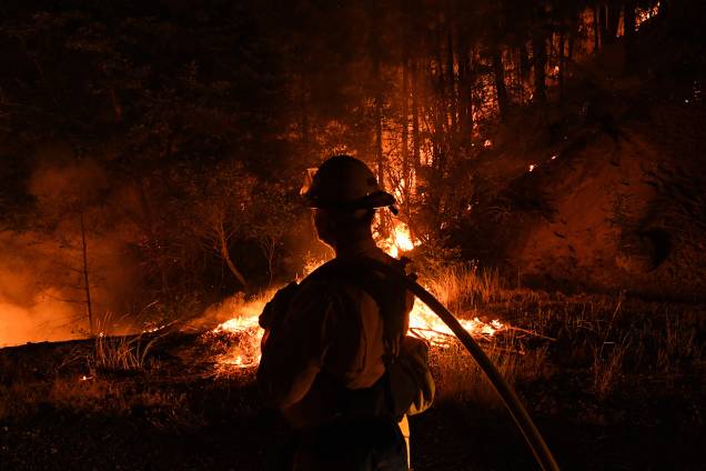 Bombeiro da unidade Lake Forest, tenta conter as chamas do incêndio Carr enquanto se espalha em direção à cidade de Douglas City, perto de Redding, na Califórnia - 30/07/2018