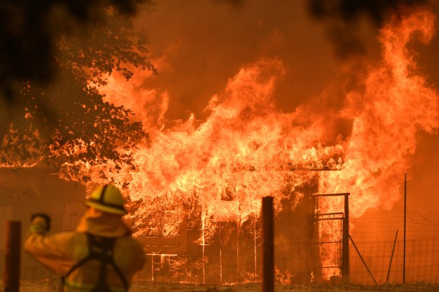 Bombeiro observa enquanto um prédio é consumido pelas chamas do incêndio no Complexo de Mendocino, em Lakeport, na Califórnia - 30/07/2018